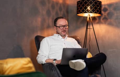 Mann mit Laptop auf dem Schoß