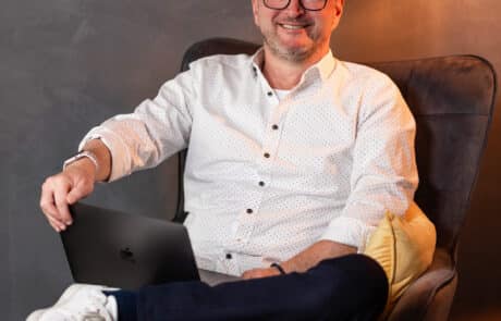Mann mit Laptop auf dem Schoß