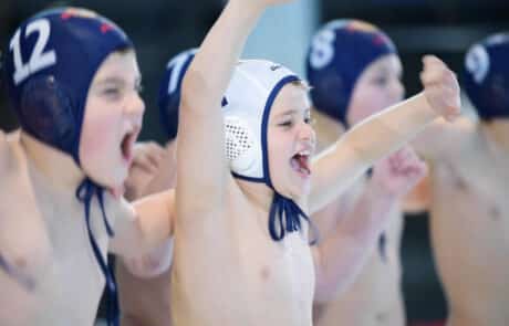 jubelnde Kinder mit Schwimmkappen