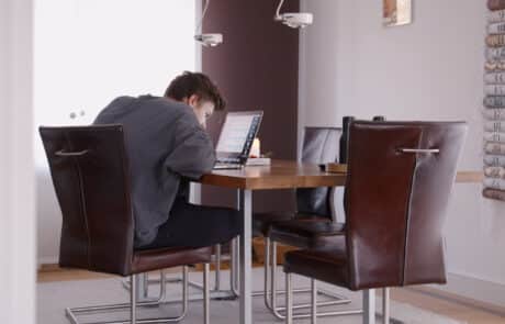Junge am Tisch mit Laptop