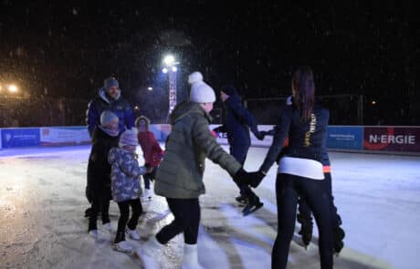 Erwachsene und Kinder beim Eislaufen